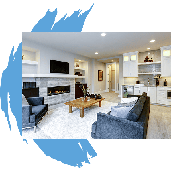 Modern living room with gray sofas, a wooden coffee table, a fireplace below a wall-mounted TV, and a kitchenette in the background. The image has a blue abstract brushstroke border—ideal inspiration for Water Damage Restoration Indiana projects.