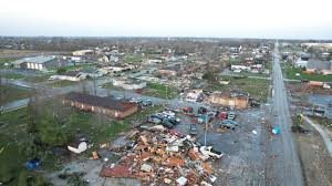 Aerial view of a town with widespread destruction, including collapsed buildings, debris, and damaged vehicles. Water Damage Restoration Service in Johnson County is essential for homes and structures heavily affected by the storm.