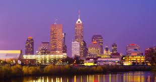 Indianapolis city skyline at dusk with buildings reflected in calm water in Marion County.