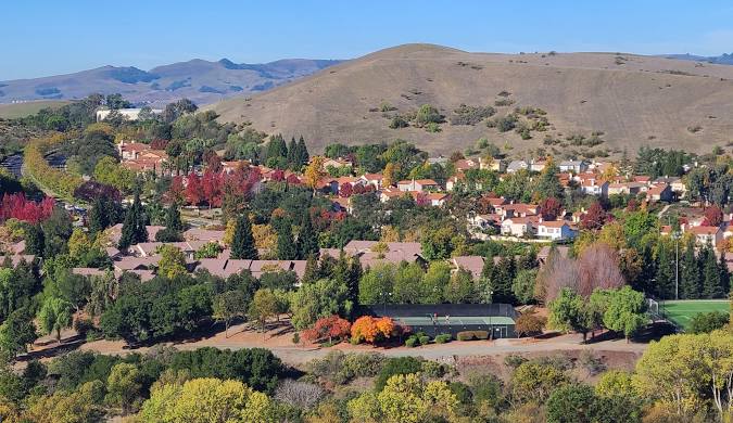 A suburban neighborhood with autumn trees and hills showcases homes in Hamilton County.